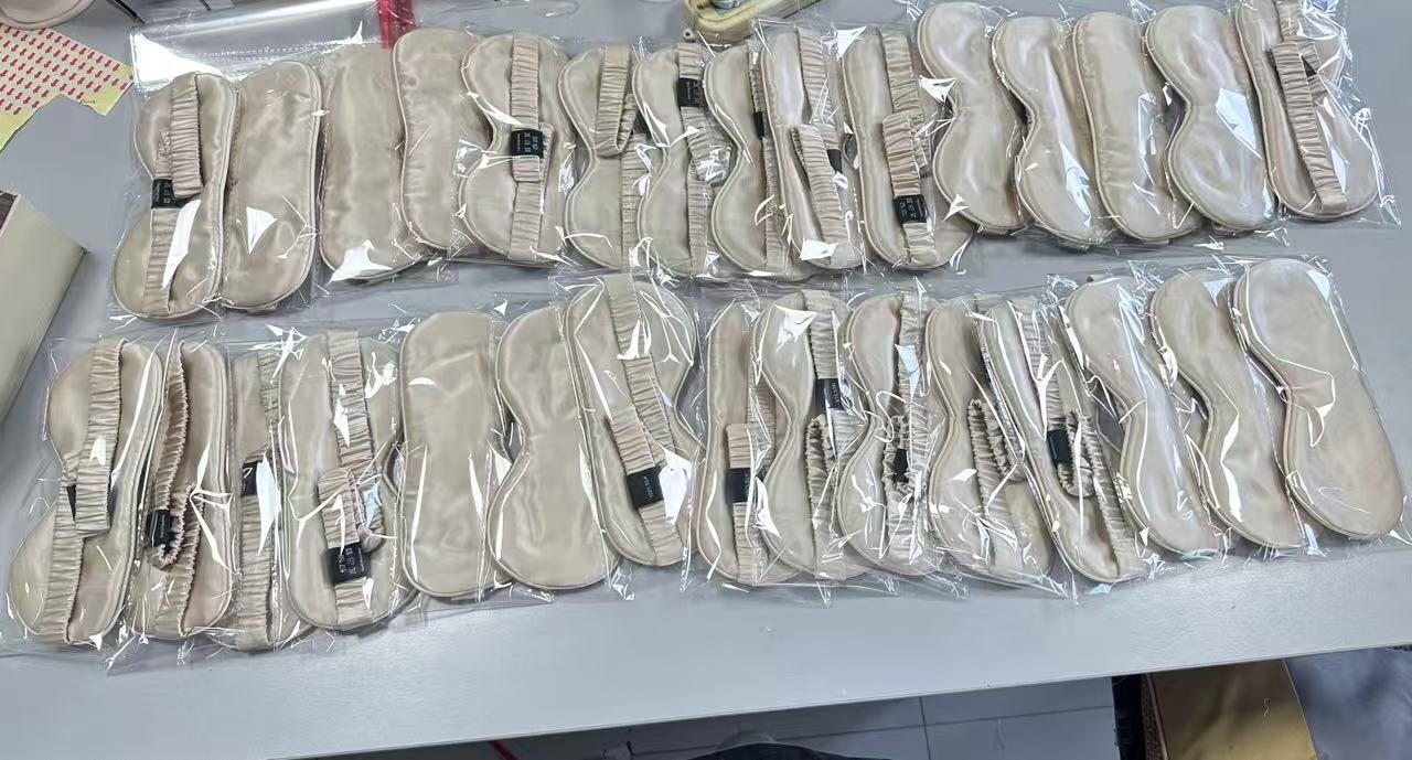 Real individually packed champagne sleep masks arranged on a worktable
